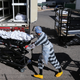 An inmate (center) works loading bodies wrapped in plastic into a refrigerated temporary morgue trailer in a parking lot of the El Paso County Medical Examiner’s office on Nov. 17, 2020 in El Paso, Texas.